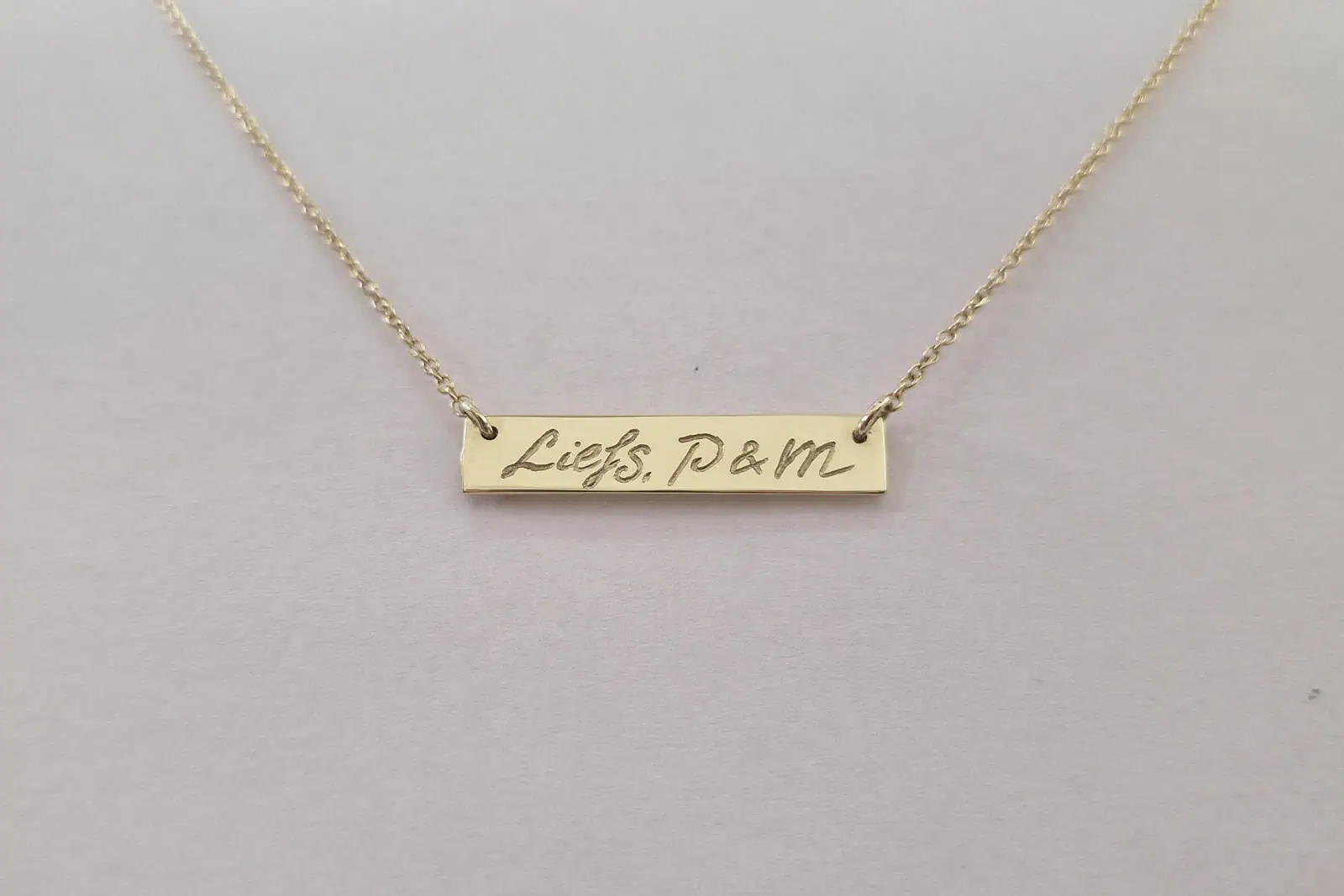 Handgesmede geelgouden hanger met gravure in eigen handschrift