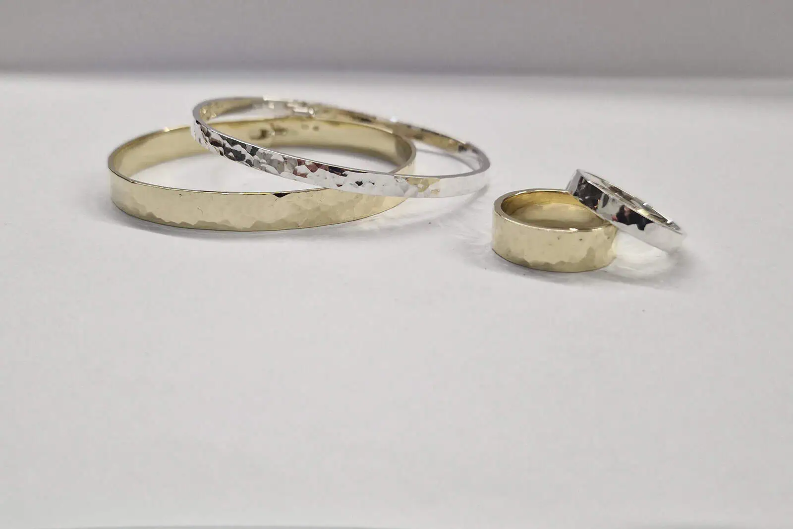 Handgesmede geelgouden en zilveren set armbanden en ringen